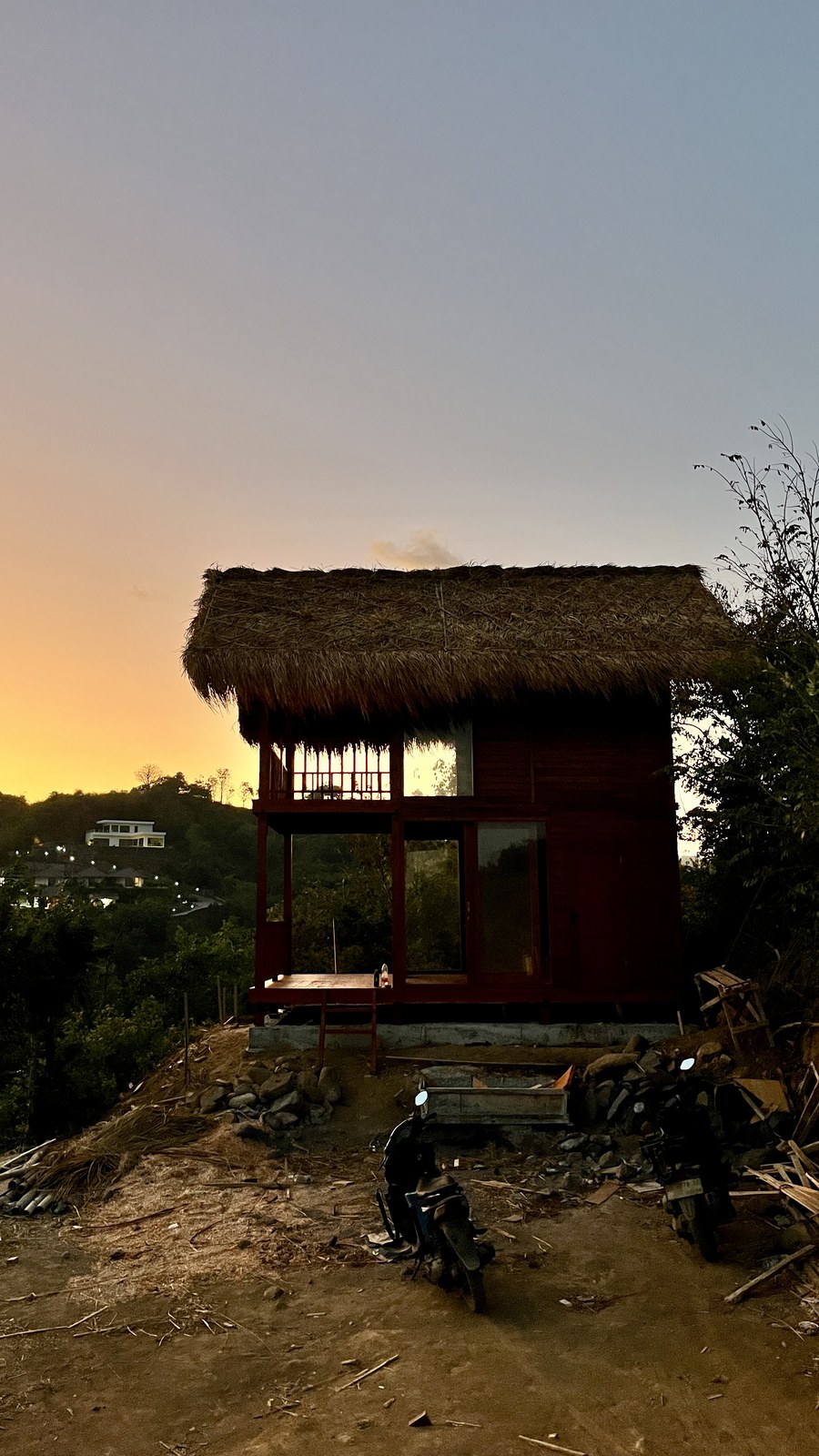 Casa con techo de thatch al atardecer en la ladera
