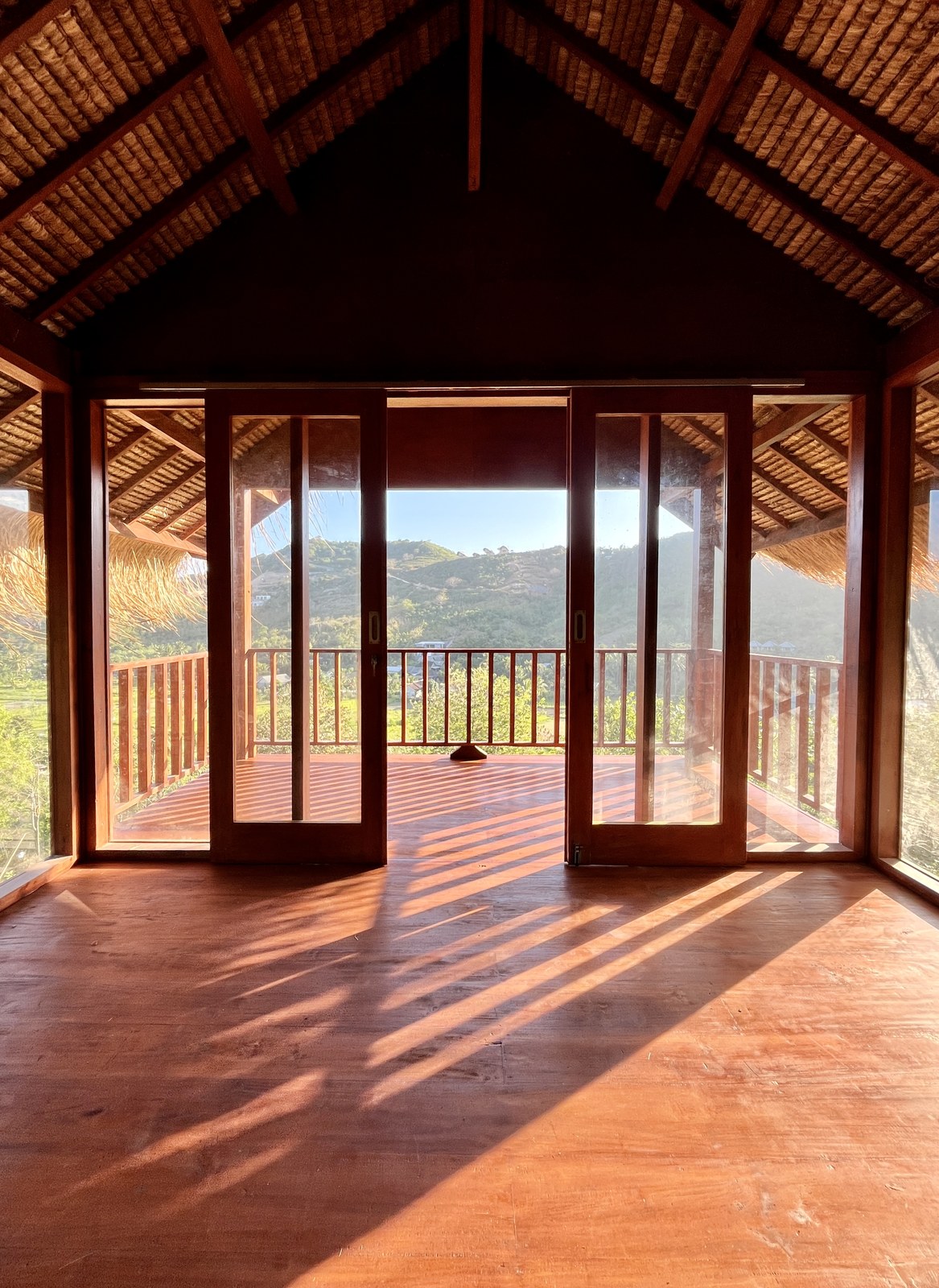Interior con pisos de madera y vista al valle desde el balcón