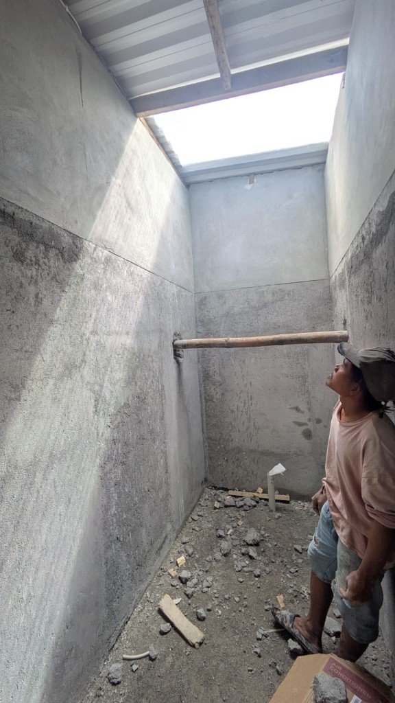 Sector de ducha del baño en obra con claraboya y desagüe